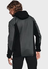 Men's hooded jacket in gray and black. Features a sleek design with a smooth texture and contrasting panels. Machine-washable fabric.