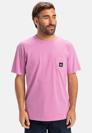 Pink bomulds T-shirt med rund hals, korte ærmer og en venstre brystlomme med et sort logo-patch. Glat tekstur og afslappet pasform.