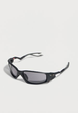 Schwarze Sportsonnenbrille mit gebogenen, dunklen rechteckigen Gläsern und belüfteten Rahmen vor weißem Hintergrund.