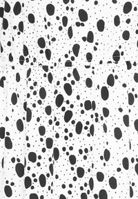 Tissu blanc avec des taches noires irrégulières de tailles variées formant un motif de pois dispersés.