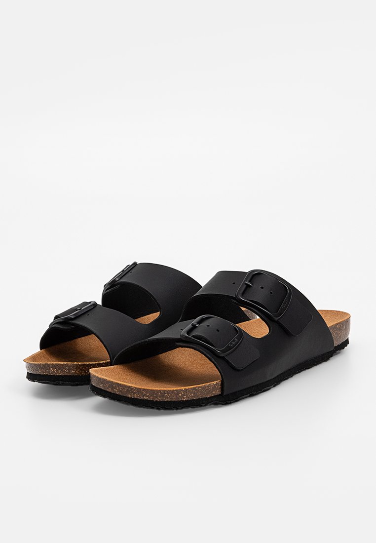 Schwarze Sandalen mit zwei verstellbaren Schnallen, Korkfußbett und strukturiertem Gummisohl. Einfaches Design mit offenem Zehenbereich und Fußgewölbeunterstützung.