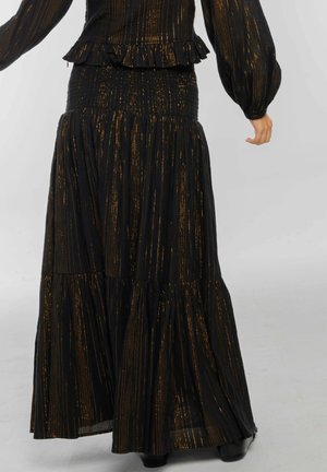 Falda maxi negra con rayas metálicas doradas verticales. Presenta un diseño en capas y una cinturilla fruncida para un aspecto texturizado.
