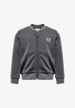 Grå zip-up jakke med rund krave, lange ærmer og ribbede manchetter. Har et lille logo på venstre bryst og et struktureret stof.