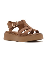 Brown suede platform sandal with adjustable buckle strap and open toe, featuring thick cushioned sole and stitched detailing.