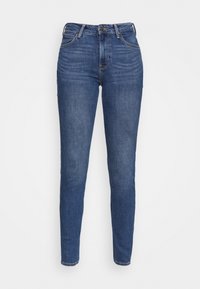 Jeans ajustados en denim azul oscuro, lavado medio, con cintura alta, diseño de cinco bolsillos y sutiles detalles de costura.