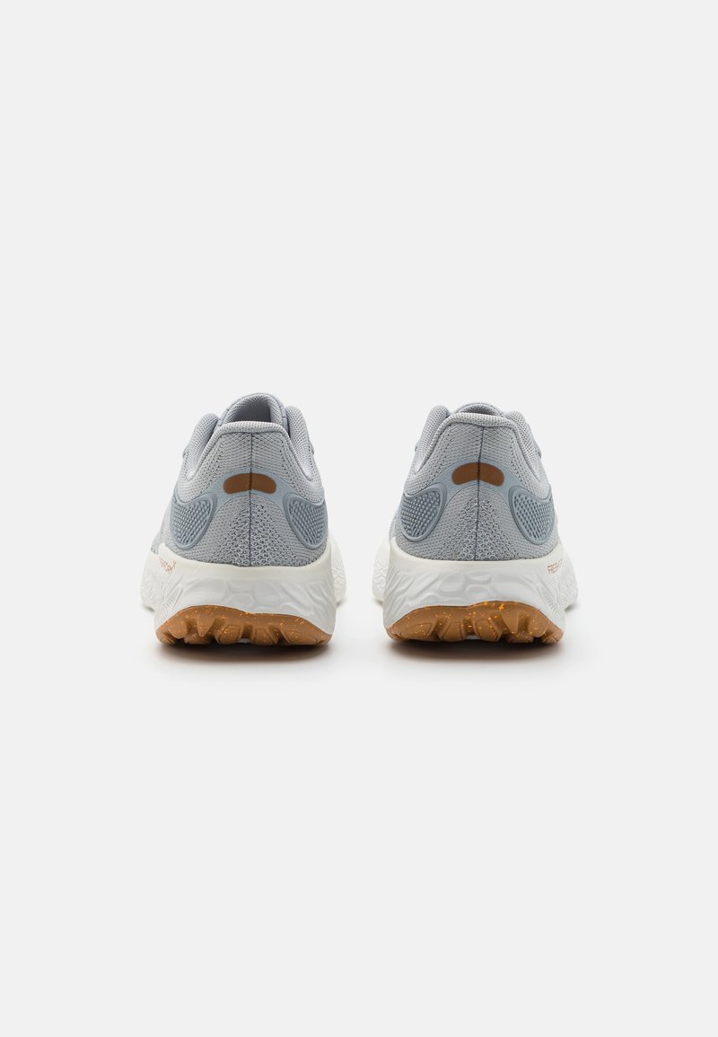 Lichtgrijze hardloopschoenen met een gemêleerde mesh bovenkant, een gevoerde kraag en een witte tussenzool. De rubberen buitenzool heeft een grip patroon.