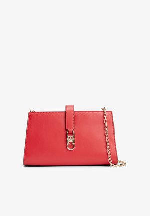 Pochette rectangulaire en cuir rouge avec une bandoulière chaîne dorée et une fermeture à boucle dorée au centre devant.