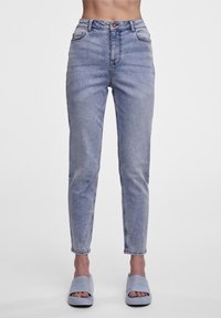 Högmidjade ljusblå jeans med rak passform, tillverkade av denim. Har framfickor, en övre knapp och subtila sömmar.