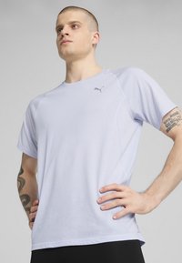 Lys lilla trænings-T-shirt lavet af fugttransporterende stof. Har korte ærmer, sømløse skuldre og et lille logo på brystet.