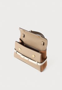 Structured leather handbag in beige and brown, featuring a white strap, two gold buttons, and a zippered interior compartment.
