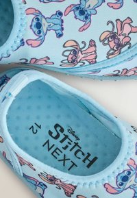 Niebieskie buty z tkaniny z kolorowymi nadrukami postaci z kreskówek Stitch i Angel, zaokrąglony nos, oraz teksturowane wykończenie wnętrza.
