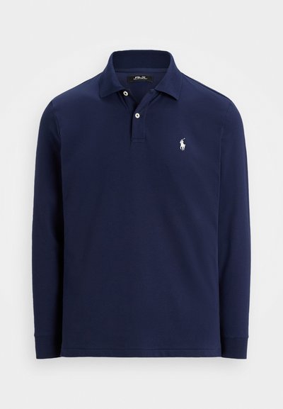 Námornícky modré polo tričko s dlhým rukávom a golierom, so zaobleným strihom, dvoma bielymi gombíkmi a malým bielym vyšitým logom koňa a jazdca na ľavej hrudi.