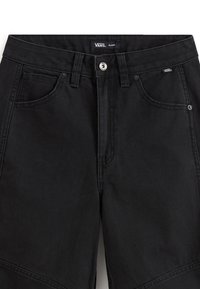 Pantalones cortos de mezclilla negros con bolsillos delanteros, trabillas para cinturón, cierre con botón de metal y pequeñas etiquetas con el logo de Vans cerca de la cintura y el bolsillo.