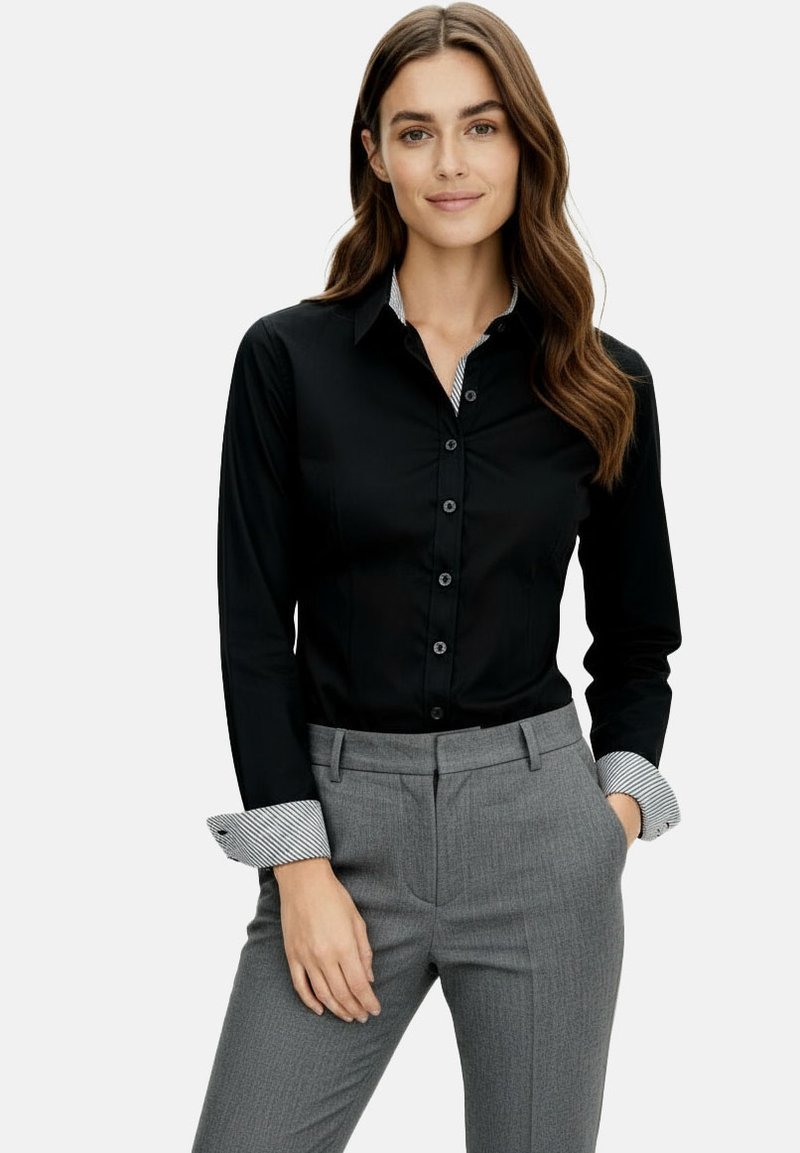 Black button-up shirt with contrasting striped cuffs, paired with tailored gray trousers. Smooth fabric, fitted design, and smooth texture.