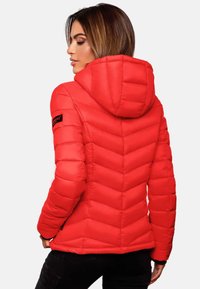 Doudoune rouge avec un motif en chevron, design ajusté et capuche. Le matériau semble lisse avec une texture brillante.