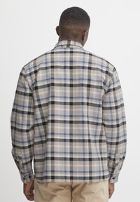 Cămașă în carouri, bej, negru și albastru deschis. Mâneci lungi cu manșete cu butoni. Material moale cu un model cu carouri. Design cu guler standard.