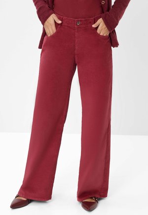 Wide-leg burgundy corduroy pants with front pockets, a front button closure, and a soft texture. Paired with pointed-toe maroon shoes.