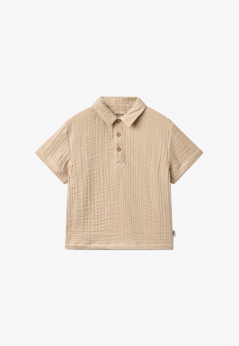 Polo beige à manches courtes texturé avec un col et trois boutons marron sur la patte de boutonnage avant.