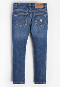 Jeans de mezclilla azul con corte recto. Presentan bolsillos traseros con detalle de logo en forma de triángulo y costuras en contraste. Parche de marca de cuero en la cintura.