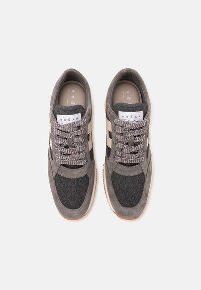 Paire de baskets de marque Hogan gris et beige avec lacets, vues de dessus sur un fond clair uni.
