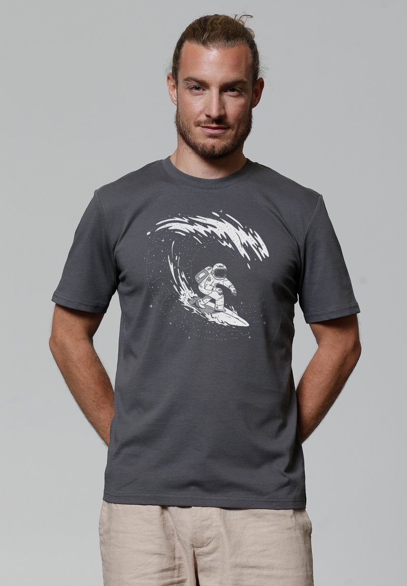 Grijze t-shirt met een witte graphic van een astronaut die op een golf surft, gemaakt van zachte katoen, met een klassieke pasvorm en korte mouwen.