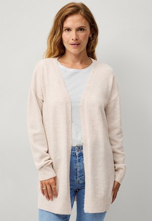 Cardigan rose clair, à devant ouvert, avec des poignets et un ourlet côtelés, texture douce, porté sur un t-shirt gris clair, associé à un jean bleu.