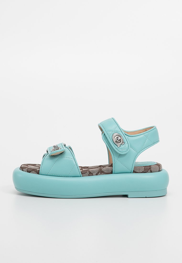 Jasnoniebieskie sandały na platformie z dwoma regulowanymi paskami, pikowaną syntetyczną cholewką i wzorzystą wyściełaną wkładką, pokazane w profilu bocznym.