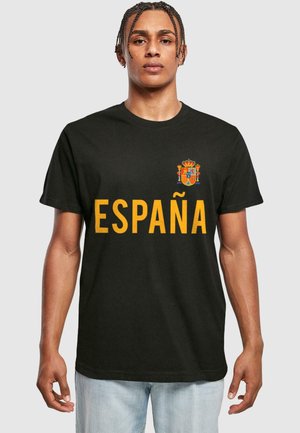 Sort t-shirt i bomuld med "ESPAÑA" i fed gul skrift og et farverigt spansk våbenskjold på venstre bryst. Korte ærmer.