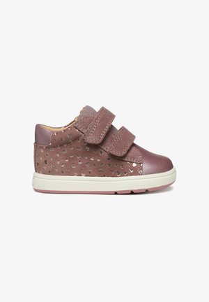 Chaussures pour enfants en cuir et daim rose avec des motifs de cœurs, dotées de doubles bandes Velcro et d'une semelle en caoutchouc blanche.