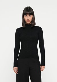Black long-sleeve turtleneck sweater made of textured fabric with a subtle patterned design, fitted silhouette, and ribbed cuffs.