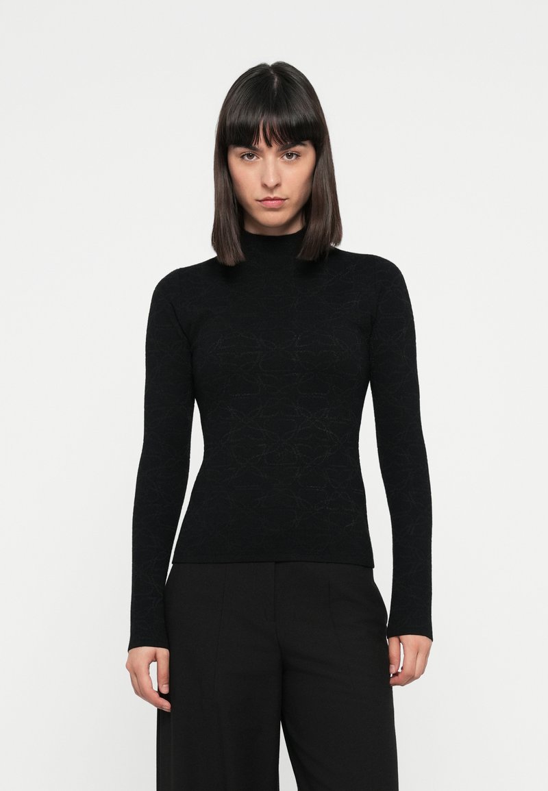 Black long-sleeve turtleneck sweater made of textured fabric with a subtle patterned design, fitted silhouette, and ribbed cuffs.