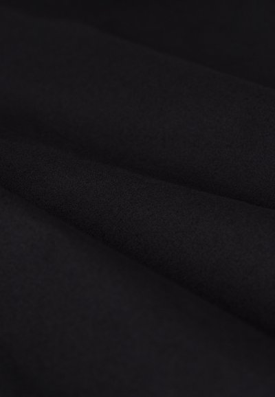 Zwarte stof met een gladde textuur, gevouwen met een subtiele glans, met een fijne, uniforme weving. Geen zichtbare patronen of hardware.