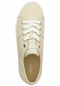 Baskets en toile beige avec des lacets blancs, logo sur la languette, bout rond et semelle en caoutchouc. Comprend des œillets métalliques et des accents cousus.