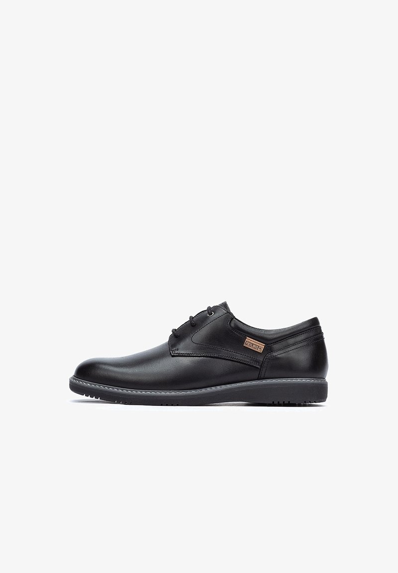 Chaussure habillée noire pour homme en cuir, à lacets, talon bas et semelle cousue, vue de profil sur fond blanc.