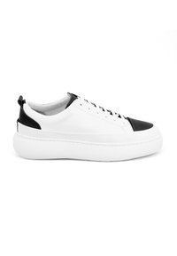 Witte leren sneaker met zwarte accenten, ronde neus, vetersluiting en dikke witte zool. Beschikt over contrasterende teencap en hieldetail.
