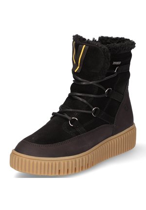 Botte d'hiver noire avec semelle en caoutchouc marron clair, doublure en fourrure, devant à lacets et languette à rayures jaunes en haut.