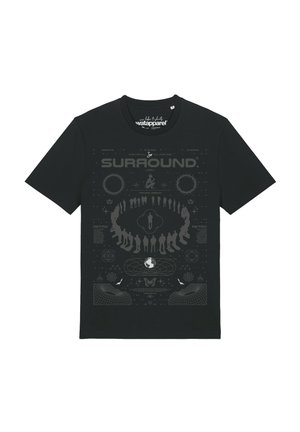 T-shirt noir avec un motif circulaire de silhouettes humaines et le mot "SURROUND" au-dessus, comprenant des éléments de design abstraits technologiques et cosmiques.