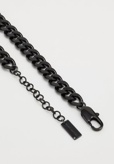 Schwarze, klobige Kette mit polierten Gliedern, ausgestattet mit einem Clipverschluss und einem kleinen Anhänger mit Markennamen. Glatte Textur und einheitliche Form.