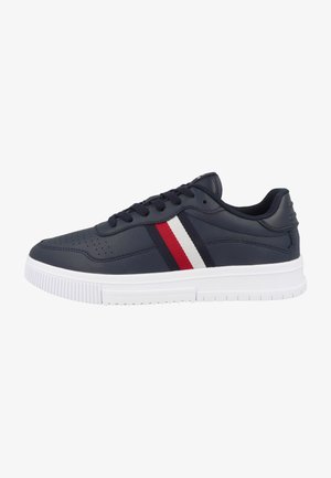 Sneaker blu navy con tomaia in pelle liscia, suola in gomma bianca e strisce rosse e bianche lungo il lato. Presenta dettagli perforati.