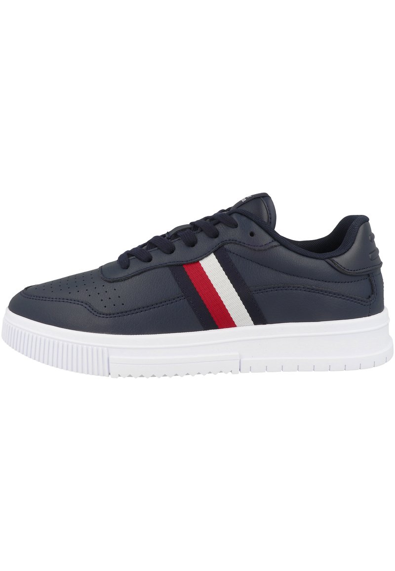 Sneaker blu navy con tomaia in pelle liscia, suola in gomma bianca e strisce rosse e bianche lungo il lato. Presenta dettagli perforati.
