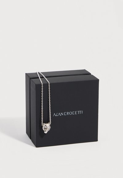 Silberne Halskette mit einem kleinen Anhänger in Katzenform, präsentiert auf zwei schwarzen Alan Crocetti Markenboxen vor weißem Hintergrund.