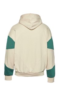 Hettegenser i kremfarge med teal detaljer på ermene, har en avslappet passform og ribbestrikket kant. Mykt stoff med minimale sømmer.