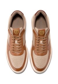 Beżowe sneakersy z brązowymi skórzanymi akcentami, okrągły fason czubka, perforowane detale na palcach oraz brązowe sznurowadła. Branding na języku i boku.