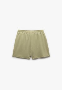 Bermuda verdi chiaro con cintura elastica, realizzate in tessuto testurizzato con un motivo a nido d'ape, progettate per comfort e libertà di movimento.