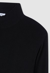 Maglione nero a collo alto con texture a costine, collo alto e maniche lunghe. Design minimalista, senza motivi o dettagli visibili.