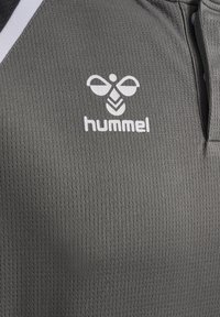 T-shirt de sport gris avec un motif texturé. Présente un logo "hummel" blanc sur la poitrine. Comprend un accent noir au niveau du col.