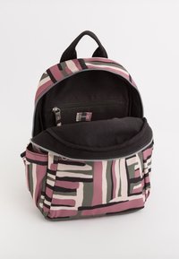Sac à dos avec un motif géométrique multicolore en rose, noir et vert ; doté d'une poche avant zippée et d'un intérieur spacieux et doublé.
