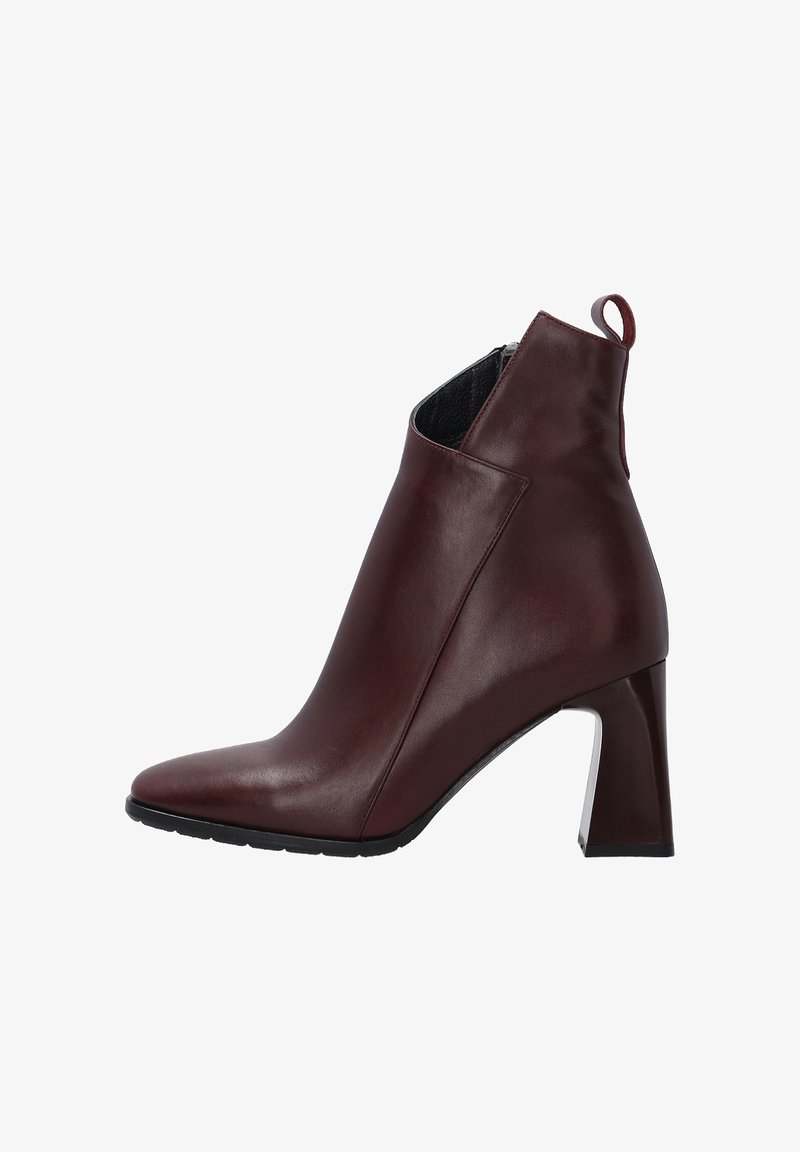 Bottine en cuir bourgogne avec un bout pointu, un talon bloc haut et une fermeture éclair. Texture lisse avec un léger éclat.