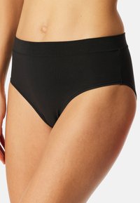 Černé bavlněné hipster kalhotky s hladkým povrchem a širokým elastickým pasem. Design zahrnuje středně vysoký střih a minimální detaily švů.
