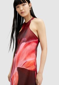 Sleeveless dress in a blend of red and pink shades with a flowing design. Features a high neckline and smooth texture, accentuating feminine lines.